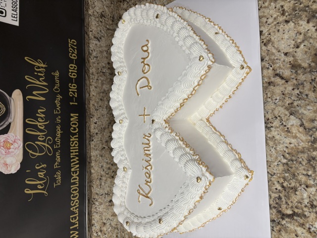White double heart cake with gold trim for a couple's celebration