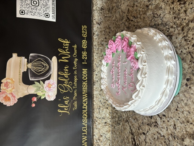 Pink and white cake with a rose corner and script greeting