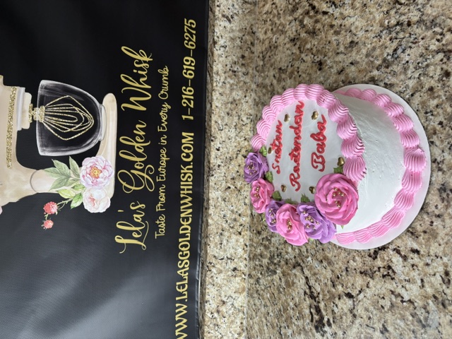 White cake with pink and purple roses and gold hearts