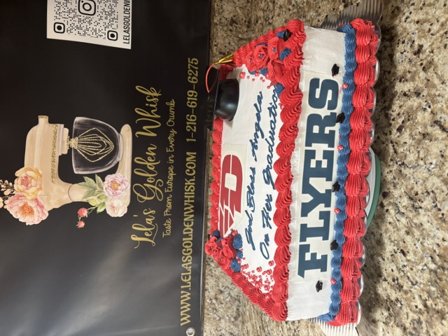 Red and blue Flyers graduation cake with rose piping