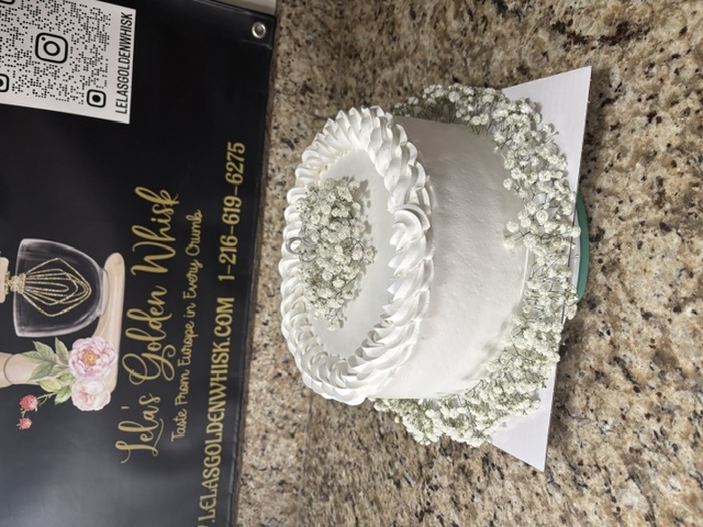 White cake with a twisted border and a flower cluster