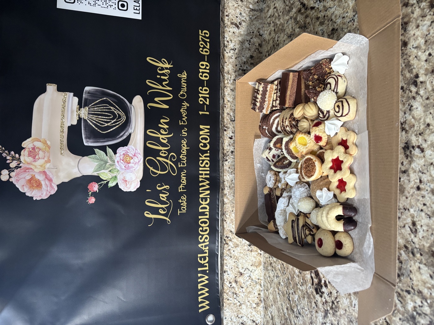 An open box of assorted cookies and pastries