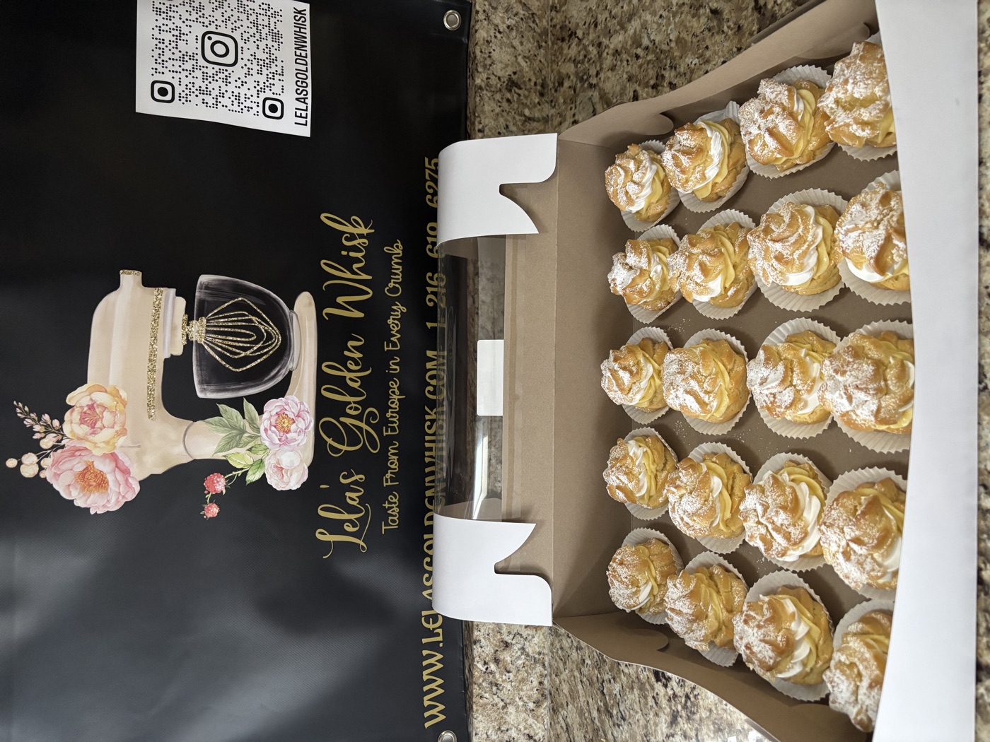 A box of cream-filled pastries dusted with powdered sugar