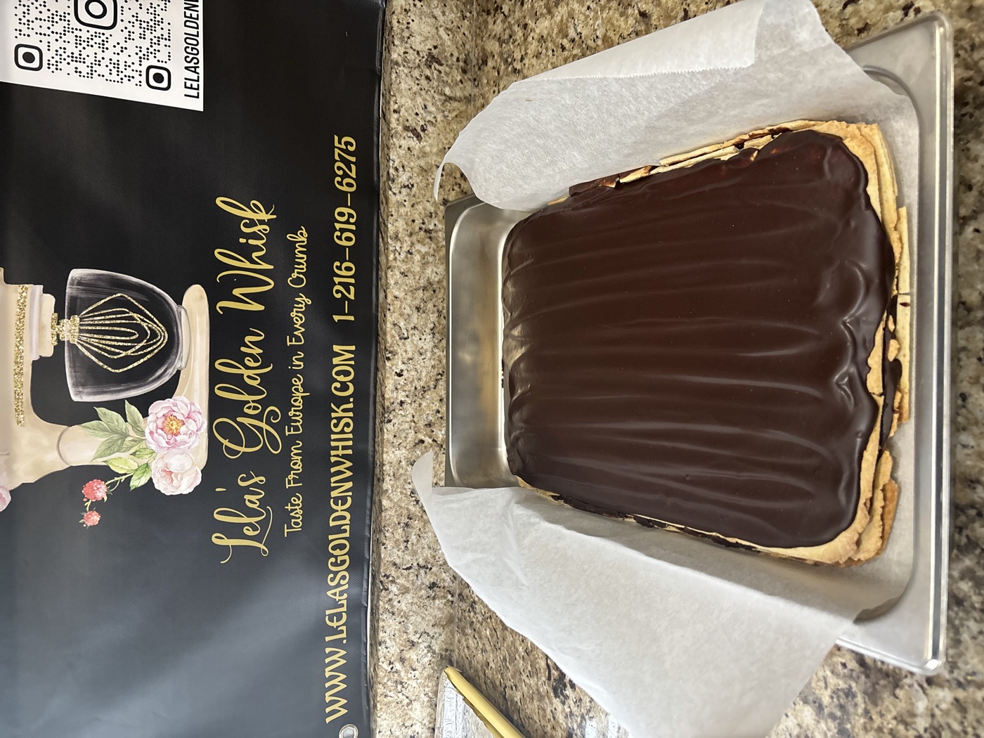 A chocolate-glazed cake in a bakery box
