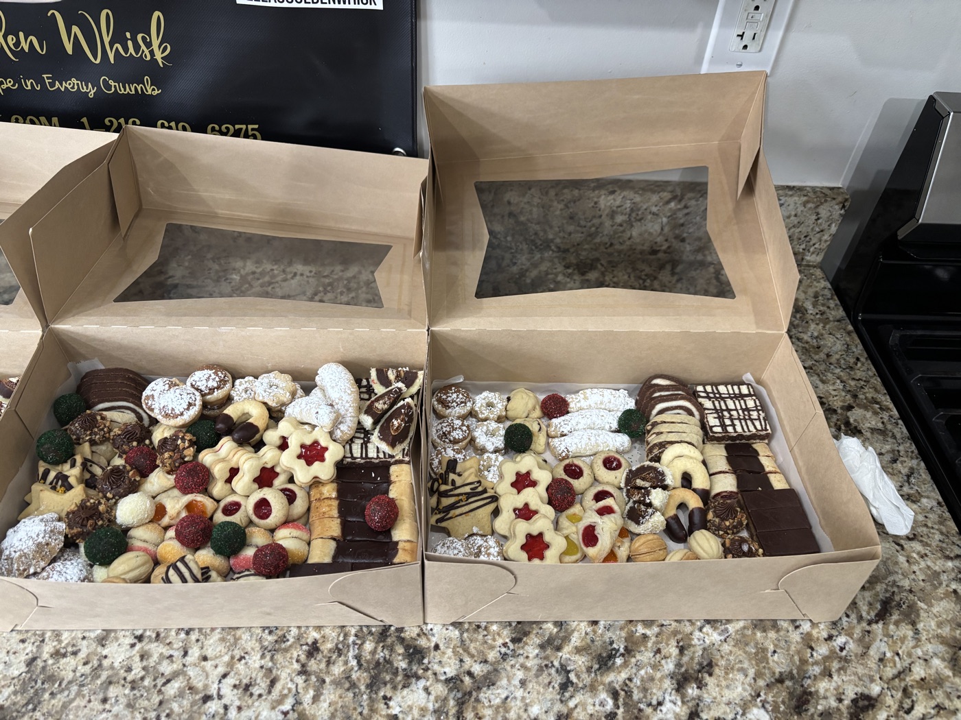 Two open gift boxes filled with assorted cookies