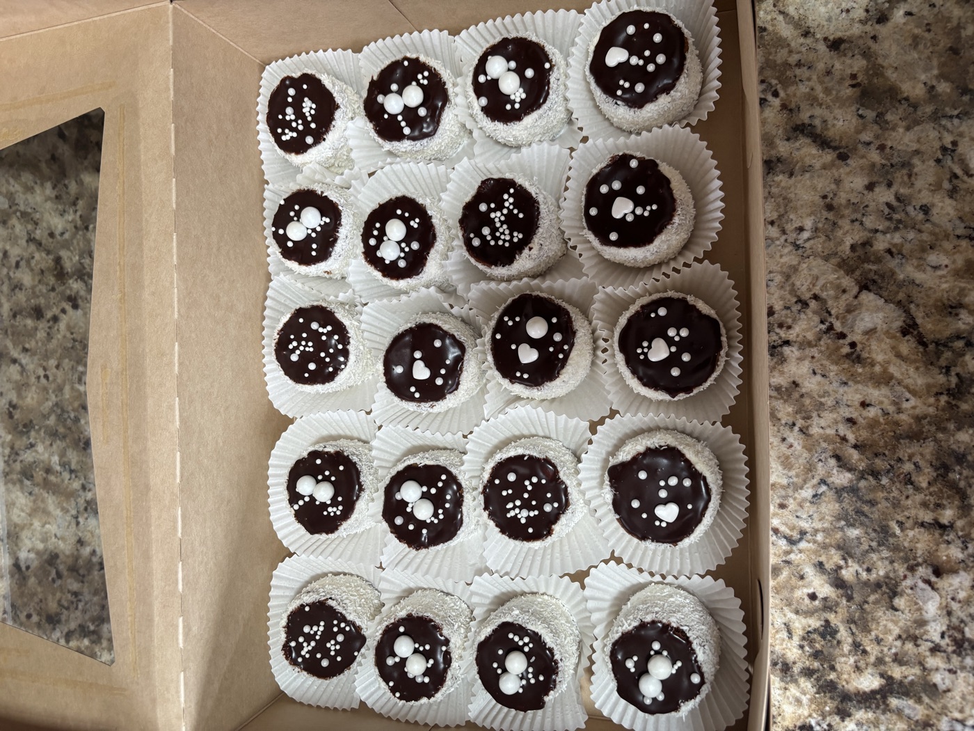 Coconut-covered sweets with chocolate centers in a box