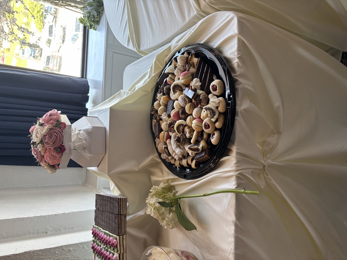 A dessert display with a cookie tray and layered pastries