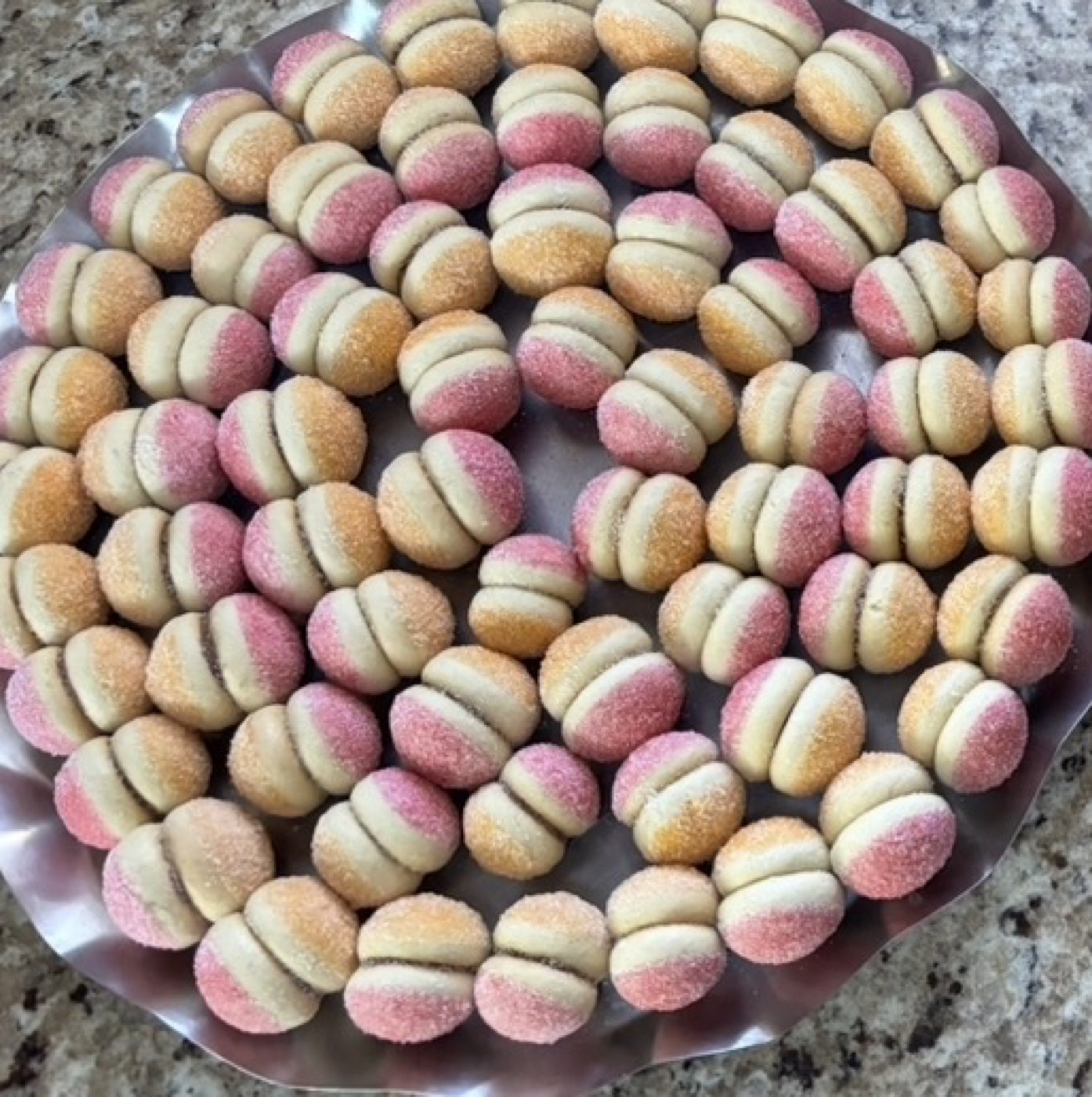 A platter filled with colorful peach-shaped cookies