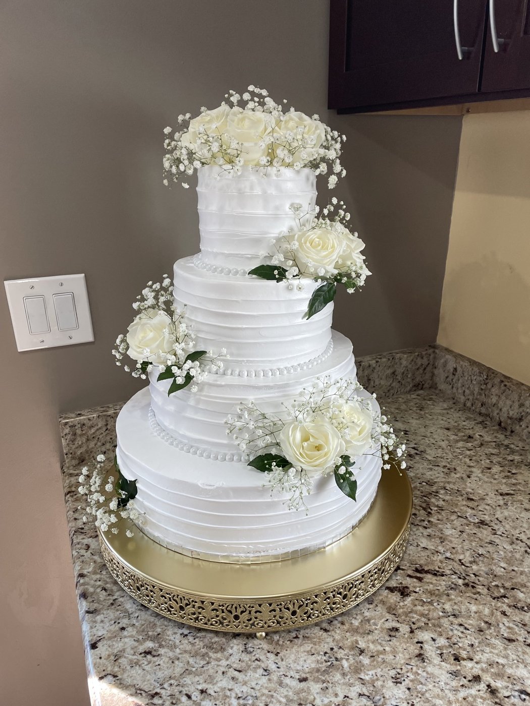 Tiered white wedding cake decorated with flowers
