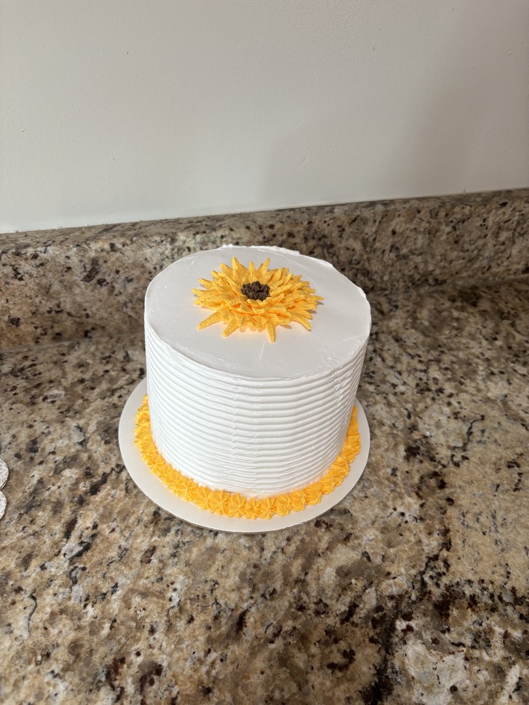 White cake with a yellow flower